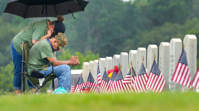 Juan and Guadalupe Macareno visit the grave of their son, Marine Cpl. Juan Martin Rincon Macareno, Jr., for Memorial Day at Houston National Cemetery on Monday, May 27, 2024 in Houston. (Brett Coomer/Houston Chronicle via AP)