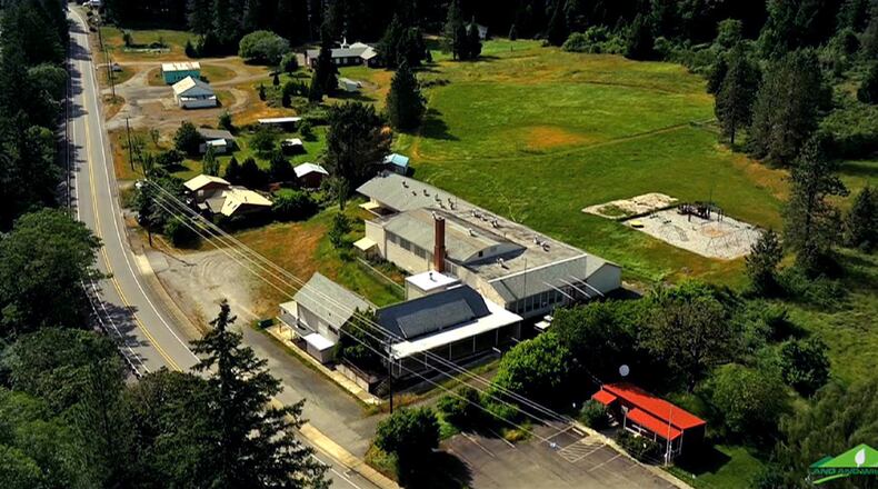 This undated aerial photo taken from a drone video and provided by LandandWildlife.com, shows Tiller, Ore. Almost all of the downtown in Tiller, a dying timber town in remote southwestern Oregon, is for sale for $3.5 million and the elementary school is for sale separately for $350,000. The asking price of $3.5 million brings with it six houses, the shuttered general store and gas station, the land under the post office, undeveloped parcels, water rights and infrastructure that includes sidewalks, fire hydrants and a working power station. (Nick Swartzendruber/LandandWildlife.com via AP)