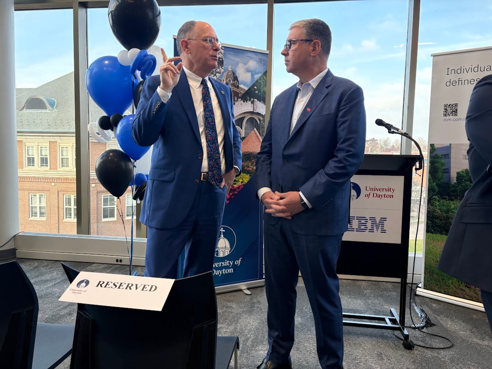 University of Dayton President Eric Spina, left, and James Kavanaugh, IBM senior vice president and chief financial officer, share a word before a campus press conference on Wednesday Nov. 19, 2025 announcing a UD-IBM semiconductor research and education partnership. THOMAS GNAU/STAFF