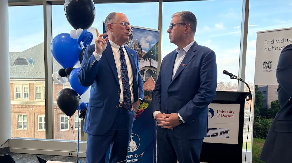 University of Dayton President Eric Spina, left, and James Kavanaugh, IBM senior vice president and chief financial officer, share a word before a campus press conference on Wednesday Nov. 19, 2025 announcing a UD-IBM semiconductor research and education partnership. THOMAS GNAU/STAFF