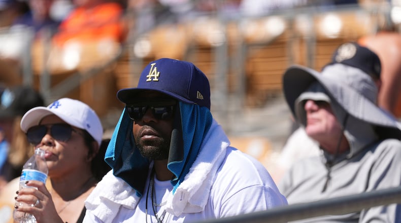 Baseball fans watch the Los Angeles Dodgers play the San Francisco Giants during the fifth inning of a spring training baseball game with the heat forcing the game to end early, Wednesday, March 18, 2026, in Phoenix. (AP Photo/Ross D. Franklin)