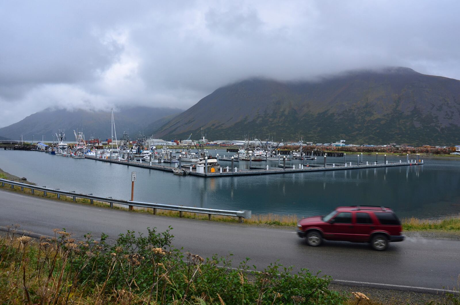 FILE - A driver passes the small boat harbor in King Cove, Alaska, Sept. 23, 2013. (James Brooks/Kodiak Daily Mirror via AP)
