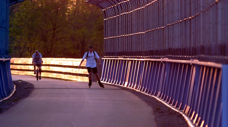 A cyclist and an in-line skater enter the bike path tunnel over the 675/35  interchange along Dayton-Xenia Rd.  near Beavercreek at sunset.