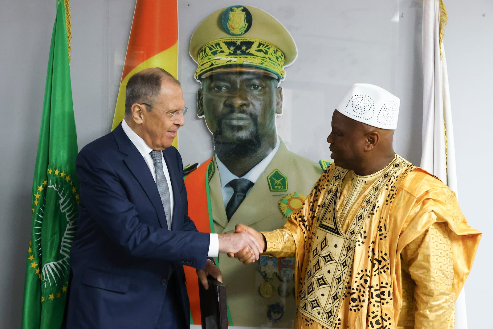 FILE - In this photo released by the Russian Foreign Ministry Press Service, Russian Foreign Minister Sergey Lavrov, left, and Guinea's Foreign Minister Morissanda Kouyate shake hands near a portrait of Guinea's President Mamadi Doumbouya in Conakry, Guinea, on June 3, 2024. (Russian Foreign Ministry Press Service via AP, File)