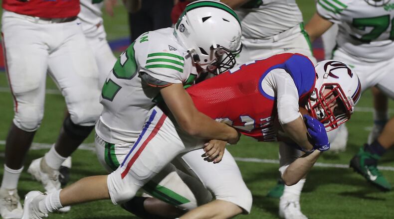 Carroll's AJ Wolfe-Smith is tackled by Badin's Nate Ostendorf as he carries the ball. BILL LACKEY/STAFF