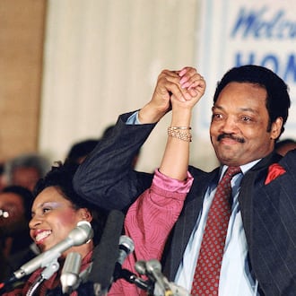 FILE - Democratic presidential hopeful Jesse Jackson with his wife, Jacqueline, salutes the cheering crowd at Operation Push in Chicago, March 10, 1988. (AP Photo/Fred Jewell, File)