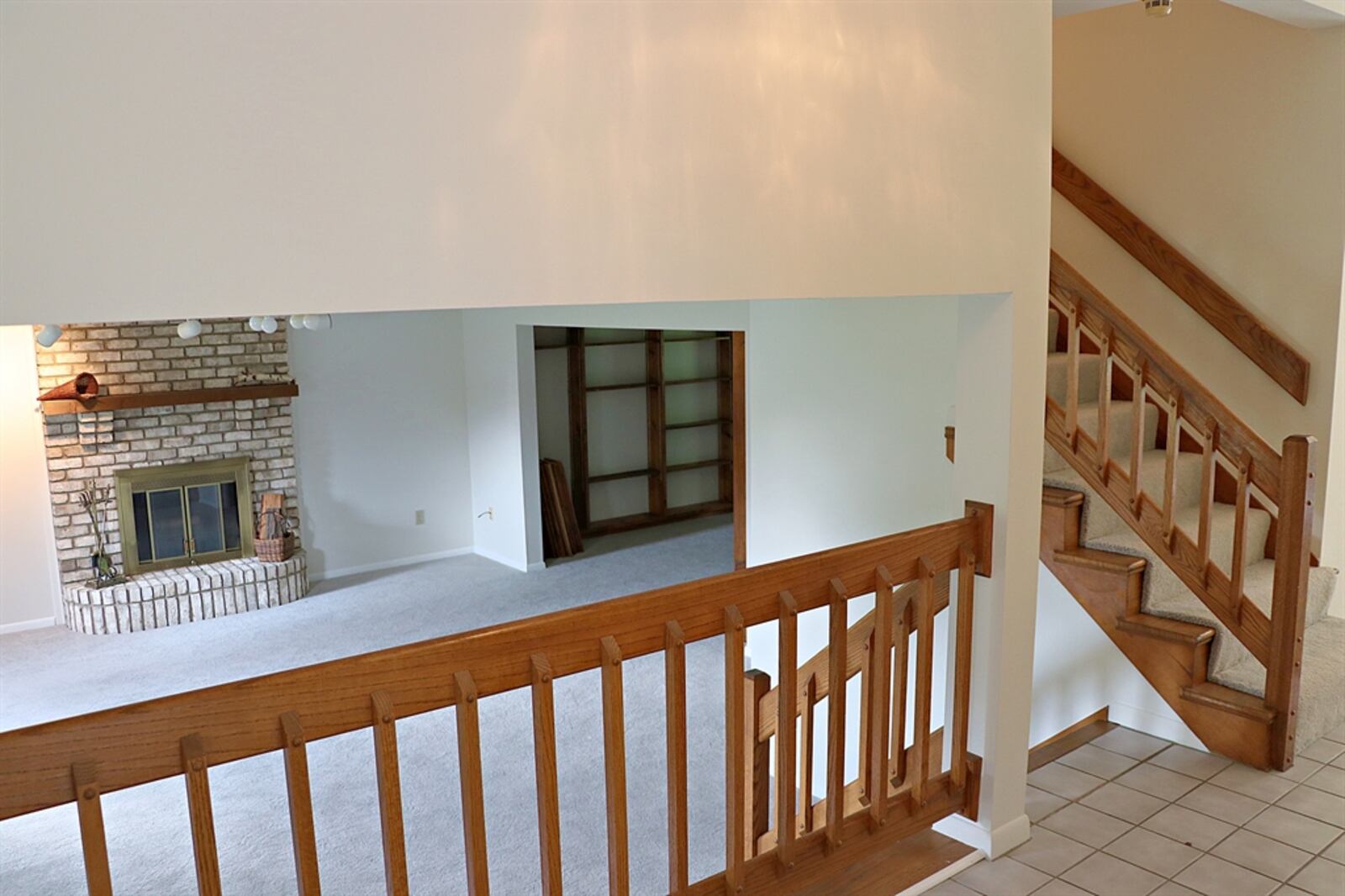 The lower level features a spacious combination space with a family room and library. The family room has a brick wood-burning fireplace with a wood-beam mantel. Daylight windows allow for plenty of natural light. The library has walls of built-in bookcases with adjustable shelves. Contributed by Kathy Tyler