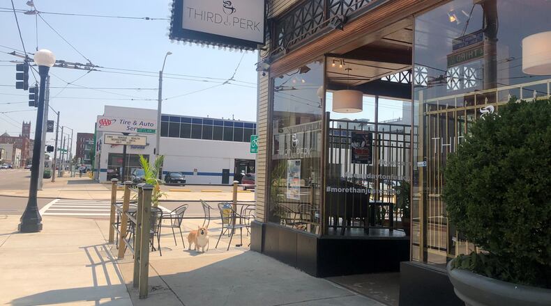A corgi barks outside on the patio of Third Perk Coffeehouse & Wine Bar at 146 E. Third St. CORNELIUS FROLIK / STAFF