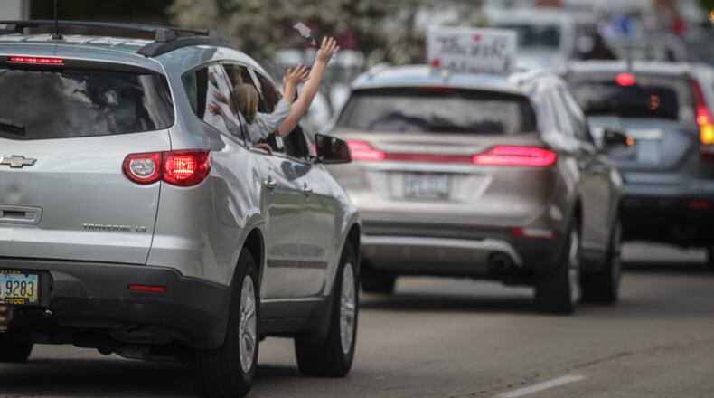 Huber Heights will hold a community car parade on Tuesday. Pictured is the parade organized by Kettering Medical Network Foundation to honor healthcare workers at the Kettering Medical Center on Southern Blvd. in Kettering. About 100 honking vehicles along with signs and waving hands drove by doctors and nurses who lined the road. JIM NOELKER/STAFF
