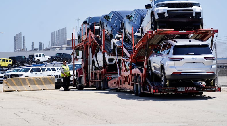 FILE - A transport carrying new cars arrives at a Stellantis facility July 10, 2023, in Belvidere. Ill. (AP Photo/Charles Rex Arbogast, File)