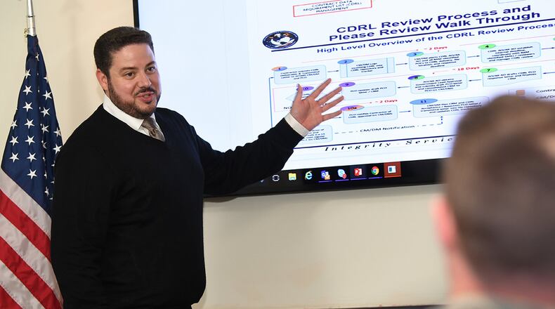 Louis Coco, a support contractor assigned to the Joint STARS Recapitalization program within the PEO Digital portfolio, demonstrates a content sharing application that allows acquisition professionals to ditch Excel, manually tracked comment resolution matrices, emails and clunky SharePoint workflow systems for cloud-hosted software solutions at Hanscom Air Force Base, Mass., Oct. 11. (U.S. Air Force photo/Todd Maki)