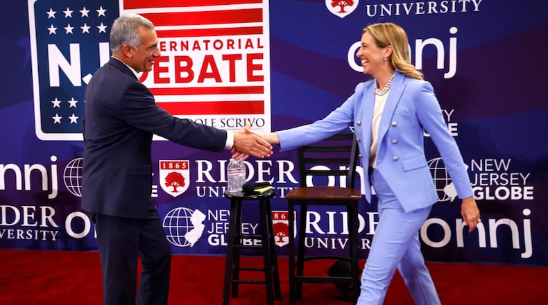 FILE - Republican candidate Jack Ciattarelli, left, shake hands with Democratic candidate for governor Mikie Sherrill, right, before a gubernatorial debate Sept. 21, 2025, in Lawrenceville, N.J. (AP Photo/Noah K. Murray, File)