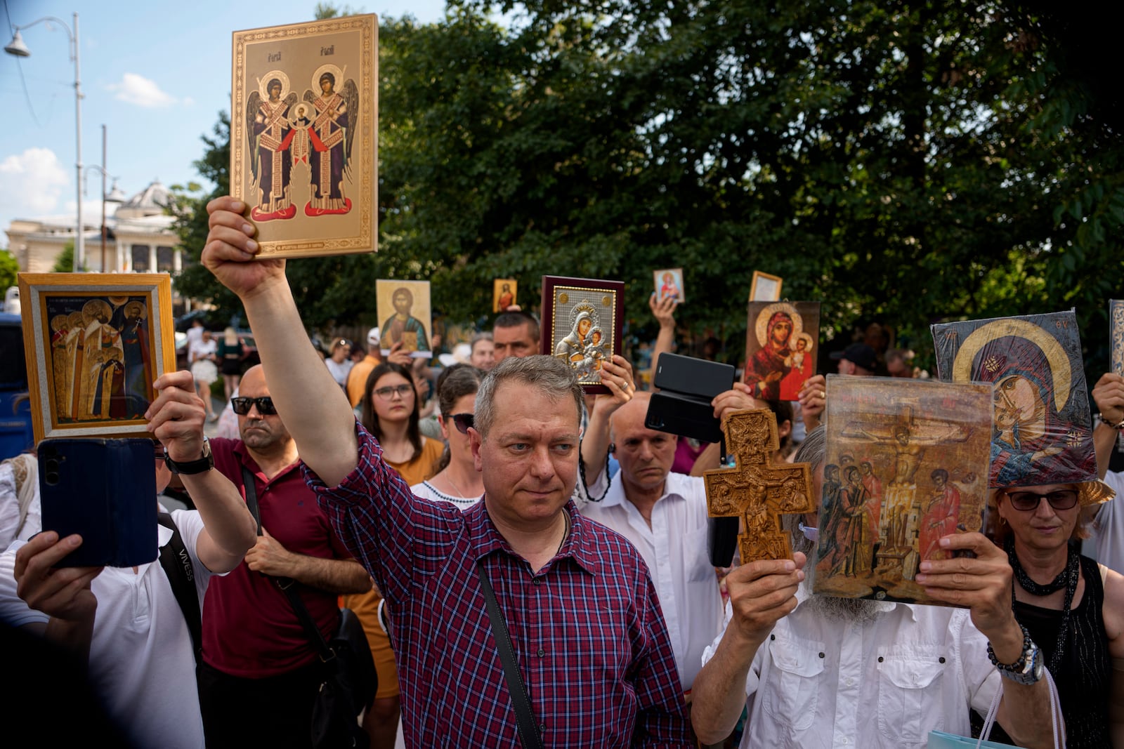 Opponents of gay rights hold religious icons during the Bucharest Pride Parade in Bucharest, Romania, Saturday, June 7, 2025. (AP Photo/Andreea Alexandru)