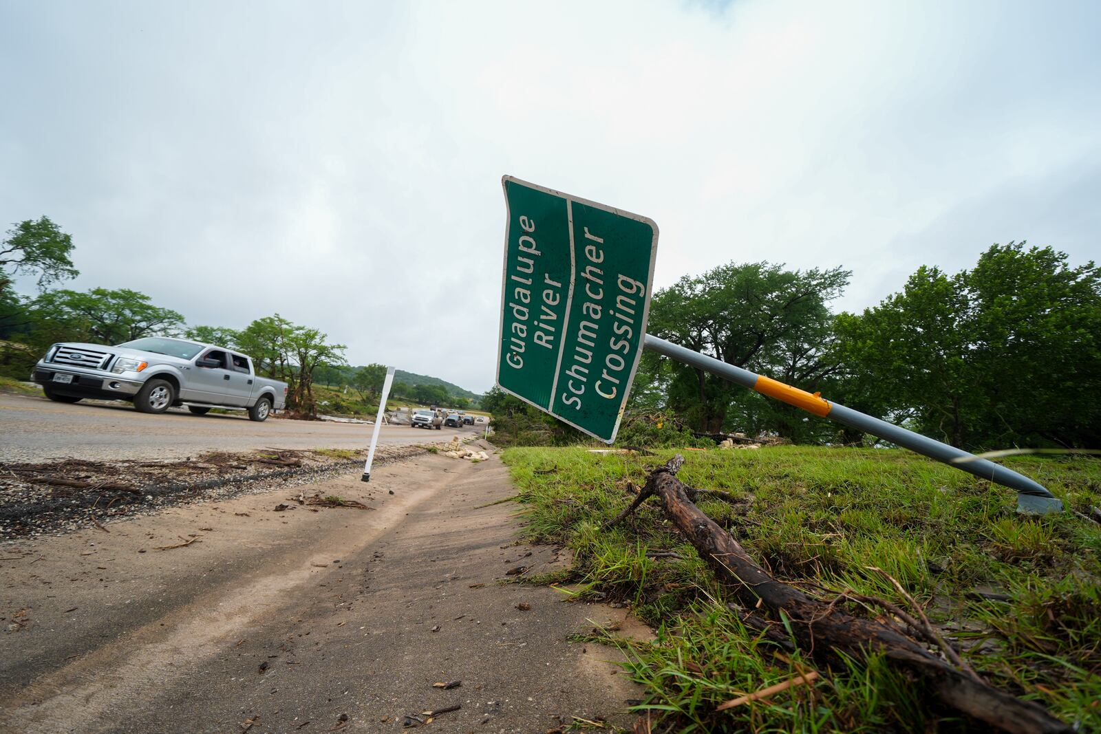 A downed sign is seen near a crossing of the Guadalupe River after a flash flood swept through the area Saturday, July 5, 2025, in Ingram. (AP Photo/Julio Cortez)
