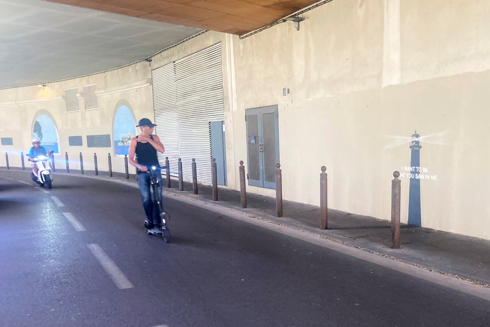 A man rides his scooter by an artwork by street artist Banksy, Friday, May 30, 2025 in Marseille, southern France. (AP Photo/Bishr Eltoni)