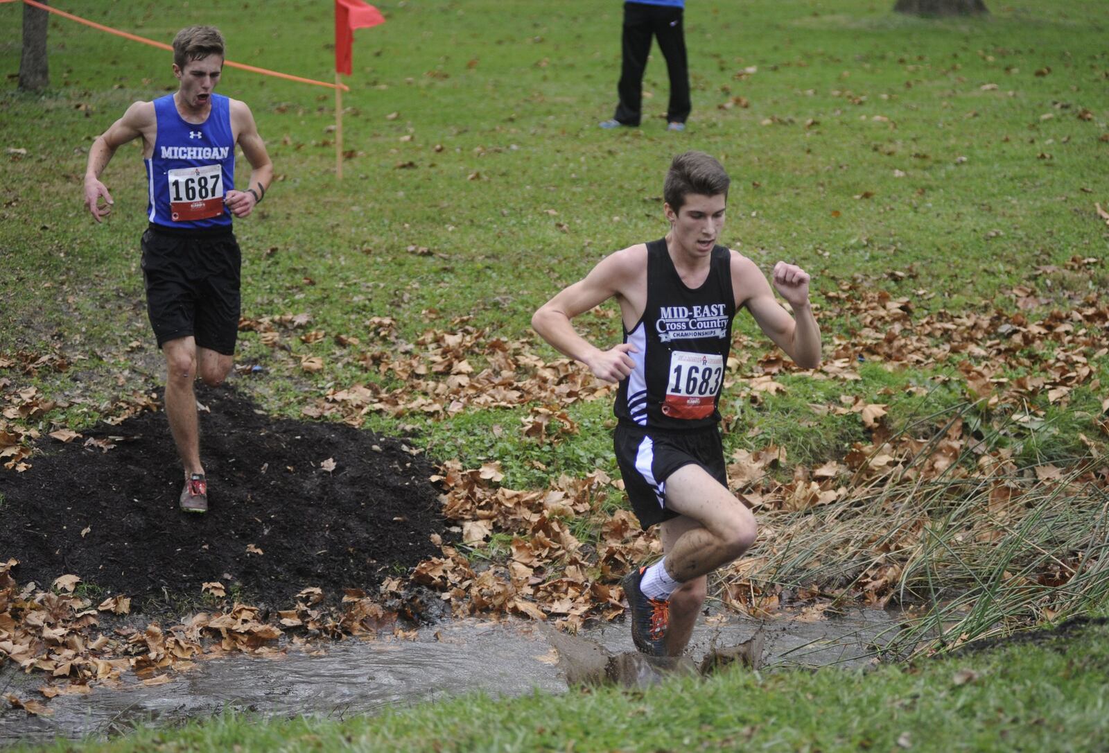 Carroll’s Karl Grossman emerges from a creek jump during the 31st annual Mid-East Cross Country Championships at Kettering’s Indian Riffle Park on Saturday, Nov. 18, 2017. MARC PENDLETON / STAFF
