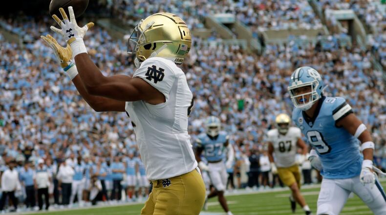 Notre Dame wide receiver Lorenzo Styles (4) hauls in a touchdown pass against North Carolina defensive back Cam'Ron Kelly (9) during the first half of an NCAA college football game in Chapel Hill, N.C., Saturday, Sept. 24, 2022 (AP Photo/Chris Seward)