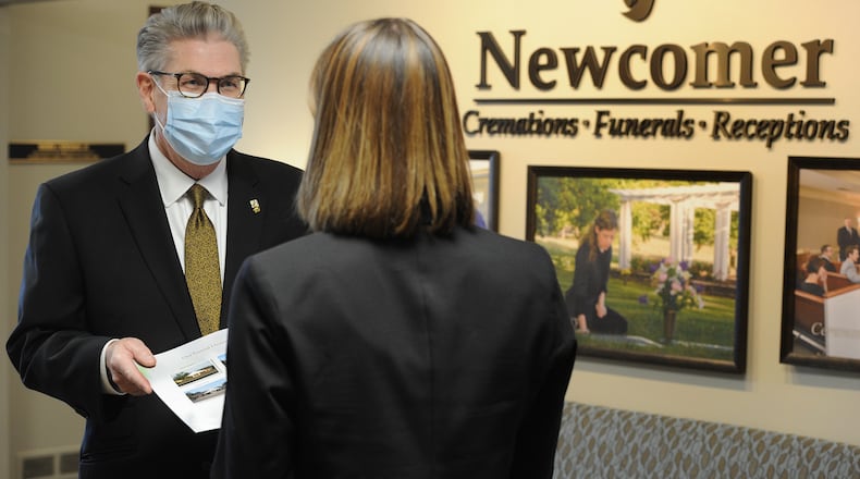 Jed J. Dunnichay, Funeral Director for Newcomer, talks with a potential client Friday, Dec. 18, 2020 at the Newcomer Cremations, Funerals and Receptions location in Centerville. MARSHALL GORBY\STAFF