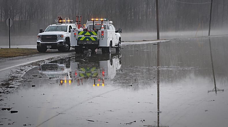 ODOT workers prepare to place "Road Closed" signage on Ohio 725 near Sackett-Wright Park in Bellbrook.  MARSHALL GORBY / STAFF