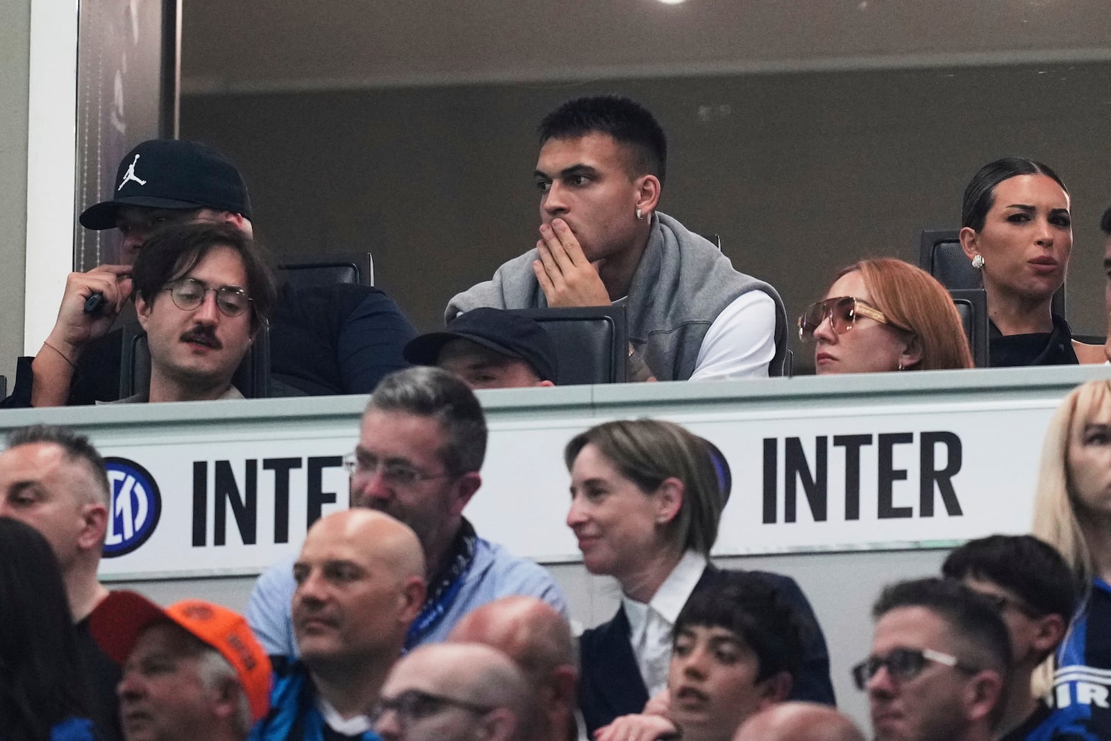 Inter Milan's Lautaro Martinez, center top, watches from the tribune during the Serie A soccer match between Inter Milan and Hellas Verona at the San Siro Stadium, in Milan, Italy, Saturday, May 3, 2025. (AP Photo/Antonio Calanni)