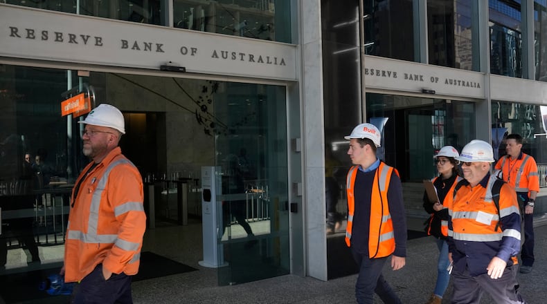 FILE - Workers in high visibility clothing walk past the Reserve Bank of Australia in Sydney, Nov. 1, 2022. (AP Photo/Rick Rycroft, File)