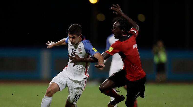 United States’ Christian Pulisic, left, fight for the ball with Trinidad and Tobago’s Nathan Lewis during a 2018 World Cup qualifying soccer match in Couva, Trinidad, Tuesday, Oct. 10, 2017. (AP Photo/Rebecca Blackwell)