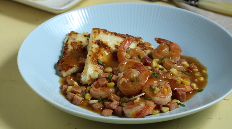 Grits are formed into cakes, then crisped in a skillet to serve as a bed for a savory mix of ham, shrimp and corn. (Joan Moarvek/food styling) (Abel Uribe/Chicago Tribune/TNS)