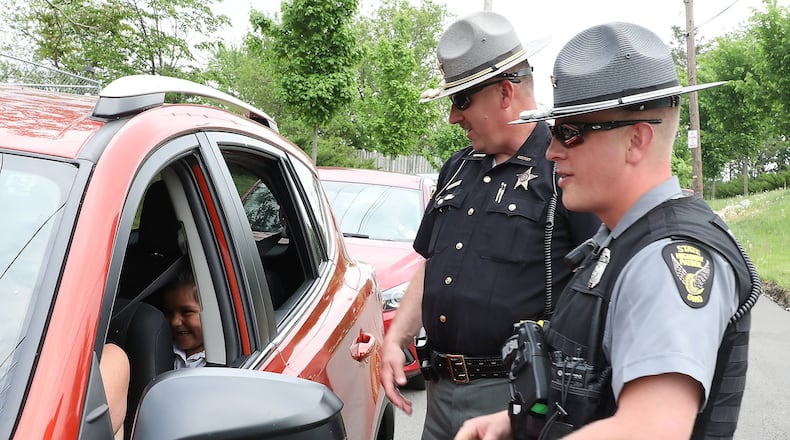 Clark County Sheriff’s Deputy Mark Lane and Sgt. Merrill Thompson of the Ohio State Highway Patrol check drivers to make sure they are wearing their seatbelts as they leaving Catholic Central High School. The safety check kicked off their Click It Or Ticket campaign that runs through June 4. Bill Lackey/Staff