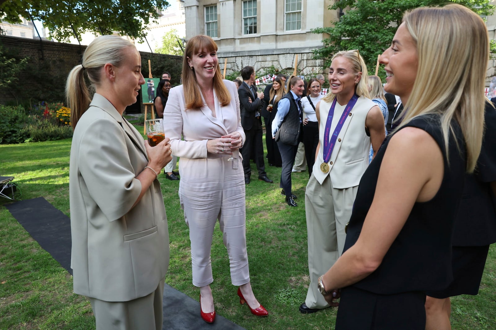 Deputy British Prime Minister Angela Rayner, second left, speaks with England's Beth Mead, left, Alex Greenwood, and Chloe Kelly, right, as they attend a special reception, to celebrate their victory in the Women's Euro 2025 final, at Downing Street in London, Monday, July 28, 2025. (Richard Pohle/Pool Photo via AP)