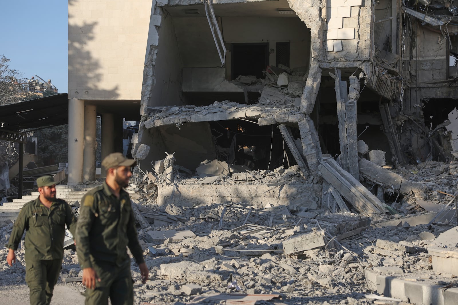 Soldiers inspect the damaged Syrian Defense Ministry building allegedly hit by several Israeli airstrikes, in Damascus, Syria, Wednesday, July 16, 2025. (AP Photo/Ghaith Alsayed)