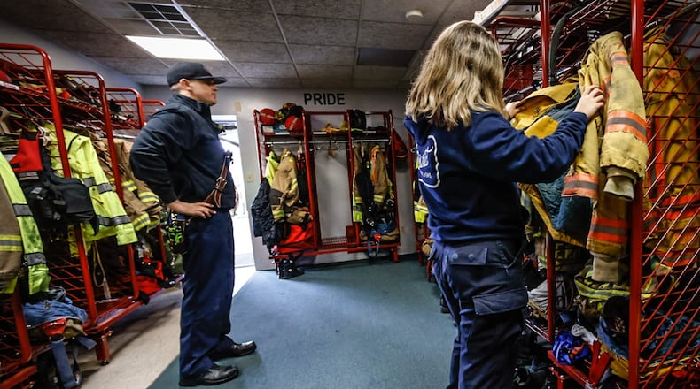 Miami Valley Fire District Battalion Chief Mike Renk (left) and firefighter/EMT Emma Brown examine old turnout gear at Station 52, 2710 Lyons Road, Miami Twp., Friday, Nov. 11, 2022. JIM NOELKER/FILE