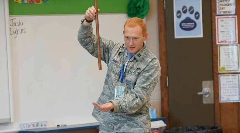 Capt. Brigham Moore, Air Force Institute of Technology/CEM, a volunteer with the Educational Outreach Program at Wright-Patterson Air Force Base, presents first graders at Clearcreek Elementary School, Springboro, Ohio, a demonstration on magnets. The Magnets Demo is one of the many programs offered by the Educational Outreach Program to attract student’s interest in careers in science, technology, engineering and math. (U.S. Air Force photo/Kwame Acheampong)
