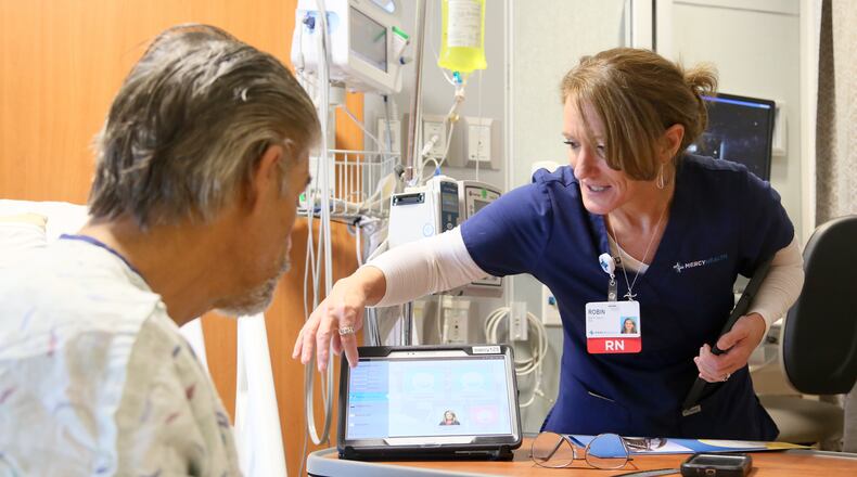 A Mercy Health nurse works with a patient in 2015. The health system is recruiting nurses and offering loan repayment assistance for certain positions. GREG LYNCH / STAFF