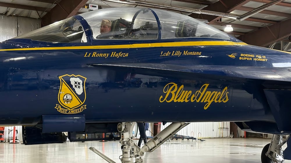 Lt. Ronny Hafeza, a Navy Blue Angels demonstration pilot, has his Boeing F/A-18 Super Hornet towed into a Wright Bros Aero hangar at Dayton International Airport Tuesday Dec. 2, 2025. Hafeza visited Dayton with Lt. Commander Lilly Montant to begin planning for the 2026 CenterPoint Energy Dayton Air Show. THOMAS GNAU/STAFF