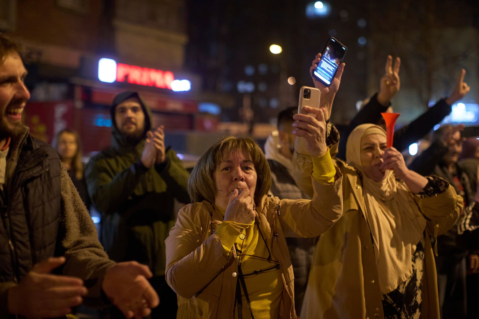 People greet a group of students who walked across the country as they arrive at an anti-corruption protest in the southwestern town of Novi Pazar, Serbia, Friday, April 11, 2025. (AP Photo/Marko Drobnjakovic)