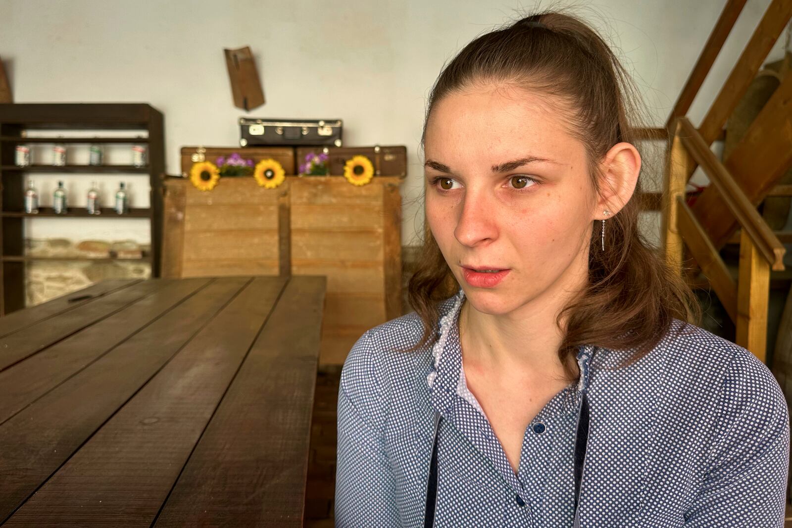 Alexandra Todea, 23, speaks during an interview with the Associated Press at the preserves factory where she works as a logistics administrator, in the village of Saschiz, in Romania's central Transylvania region, Friday, April 25, 2025. (AP Photo/Stephen McGrath)
