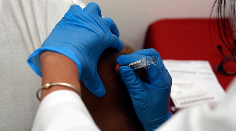 A pharmacist administers a COVID-19 vaccine at a pharmacy in New York, on Tuesday, Sept. 24, 2024. (AP Photo/Mary Conlon)