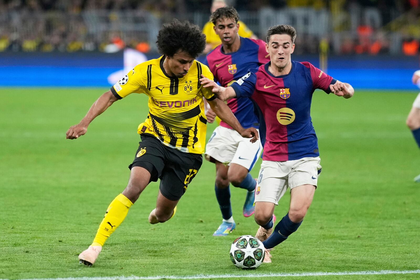 Barcelona's Gavi, right, challenges Dortmund's Karim Adeyemi during the Champions League quarterfinals second leg soccer match between Borussia Dortmund and Barcelona, at the Signa-Iduna Park in Dortmund, Germany, Tuesday, April 15, 2025. (AP Photo/Matthias Schrader)