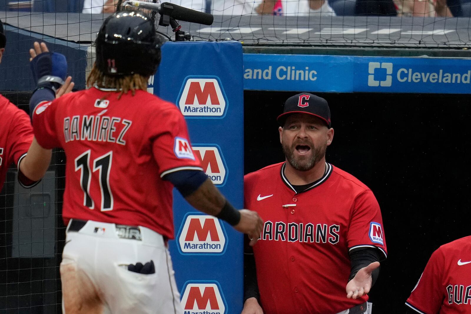 Cleveland Guardians manager Stephen Vogt, right, greets Jose Ramirez (11) as he returns to the dugout after scoring in the sixth inning of a baseball game against the Milwaukee Brewers in Cleveland, Monday, May 12, 2025. (AP Photo/Sue Ogrocki)