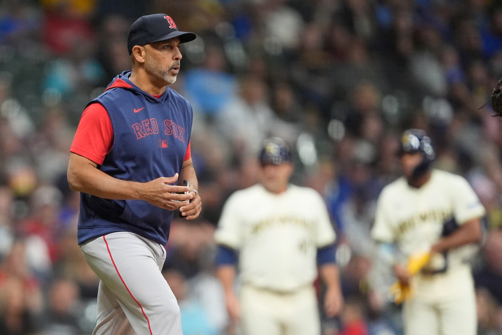Boston Red Sox manager Alex Cora walks to the mound to make a pitching change during the sixth inning of a baseball game against the Milwaukee Brewers, Tuesday, May 27, 2025, in Milwaukee. (AP Photo/Aaron Gash)