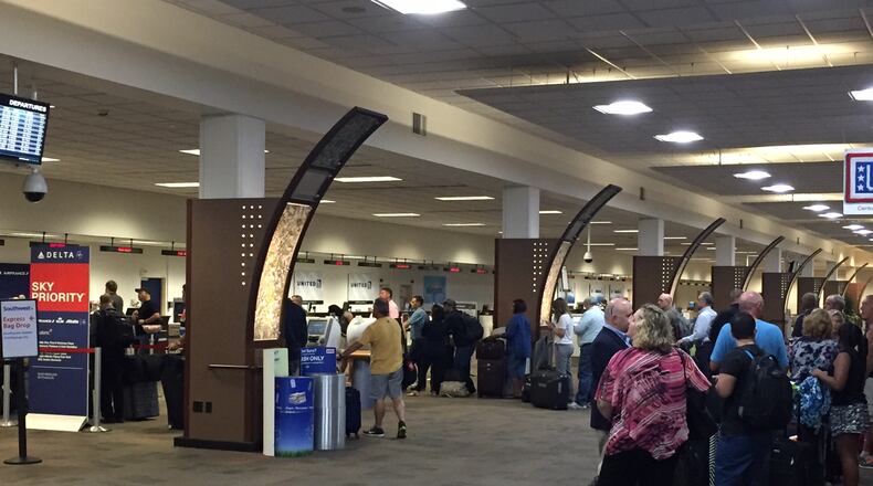 Travelers wait in long lines at Delta at Dayton International Airport Monday morning. JAROD THRUSH/STAFF
