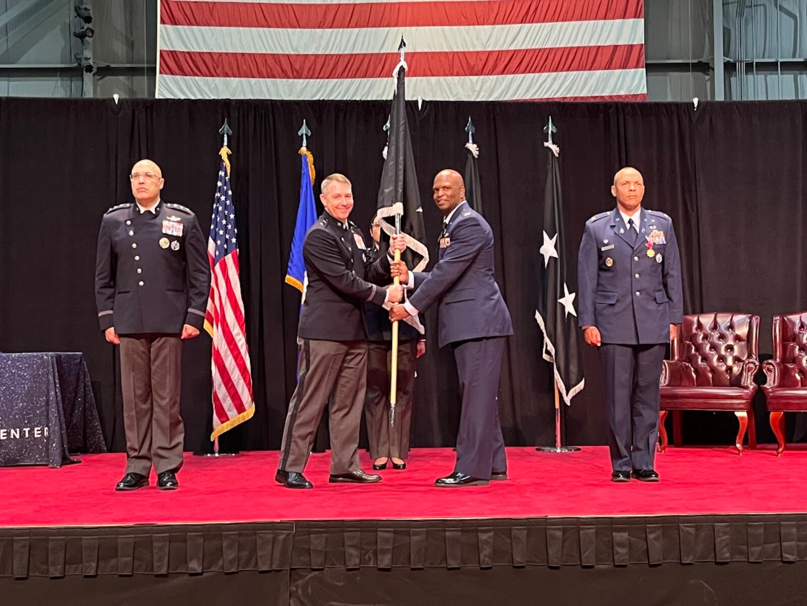 Space Force Col Marcus Starks, to the immediate right of the military guidon or banner, accepted command of the National Space Intelligence Center at Wright-Patterson Air Force Base Friday. Handing off the guidon, on the banner's immediate left, was Maj. Gen. Gregory Gagnon. THOMAS GNAU/STAFF
