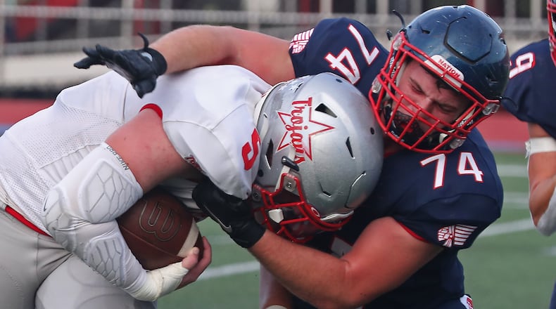 Piqua's Derek Jones tackles Troy's Andrew Helman during Friday's game at Piqua. BILL LACKEY/STAFF