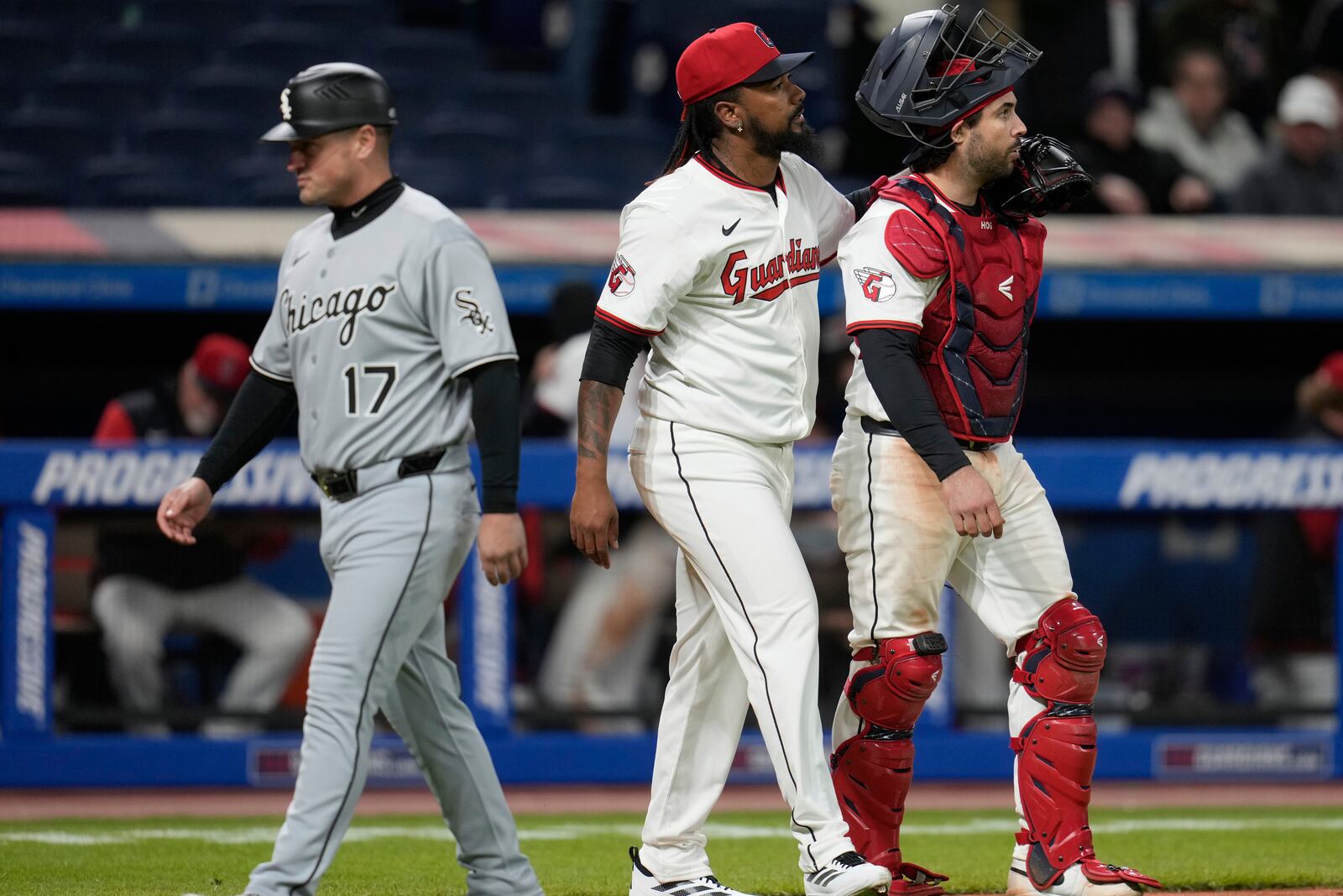 Cleveland Guardians relief pitcher Emmanuel Clase, center and catcher Austin Hedges, right, walk off the field past Chicago White Sox third base coach Justin Jirschele (17) after the Guardians defeated the White Sox in a baseball game in Cleveland, Wednesday, April 9, 2025. (AP Photo/Sue Ogrocki)