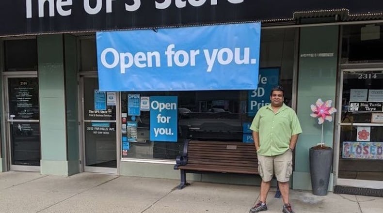 Ashwin Narayan, in front of his UPS store in Oakwood, is making free OPEN signs for businesses amid the coronavirus pandemic.