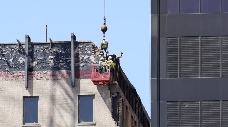 Workers remove bricks from the top of the former Key Bank Building at 34 N. Main St. on April 23, 2025. BRYANT BILLING / STAFF