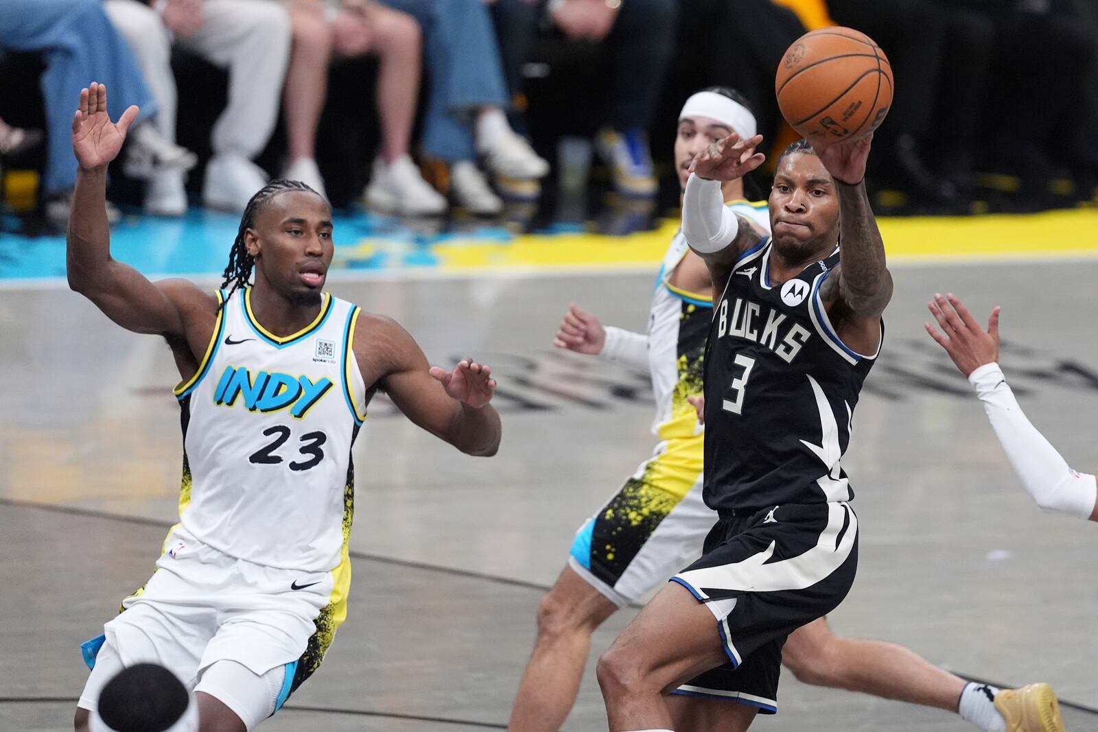 Milwaukee Bucks' Kevin Porter Jr. (3) passes as Indiana Pacers' Aaron Nesmith (23) watches during the first half of a first-round NBA basketball playoff game, Saturday, April 19, 2025, in Indianapolis. (AP Photo/Michael Conroy)