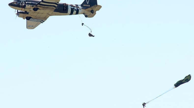 World War II paratroop reenactors jump from Tico Belle, a C-47 Skytrain, on April 27 over the National Museum of the U.S. Air Force at Wright-Patterson Air Force Base. The aircraft, a veteran of the D-Day invasion, then landed on the runway behind the museum and sat on display until its departure the next day. U.S. AIR FORCE PHOTO/R.J. ORIEZ