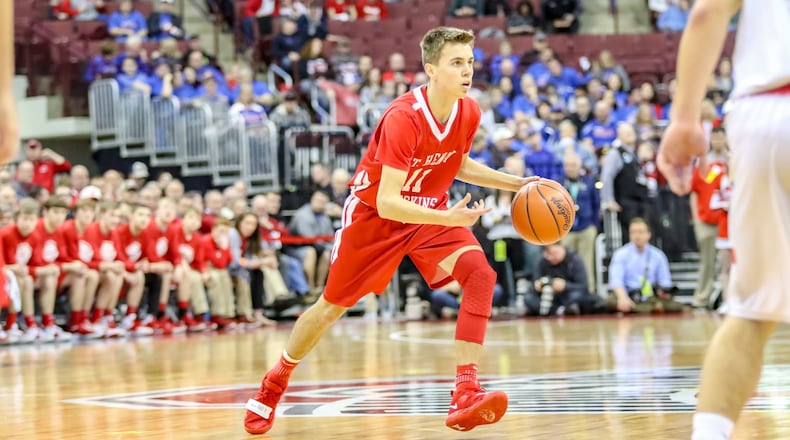 St. Henry’s Riley Link dribbles the ball at the top of the key during a Division IV state semifinal game against Berlin Hiland on Friday afternoon at the Ohio State University Jerome Schottenstein Center. The Redskins fell to the Hawks 57-50. CONTRIBUTED PHOTO BY MICHAEL COOPER