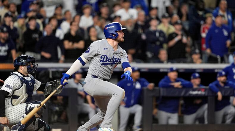 Los Angeles Dodgers' Gavin Lux, right, watches his sacrifice fly against the New York Yankees during the eighth inning in Game 5 of the baseball World Series, Wednesday, Oct. 30, 2024, in New York. (AP Photo/Godofredo A. Vásquez)